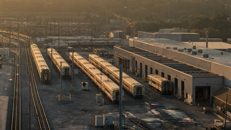 Commuter rail maintenance yard with trains staged outside the shop